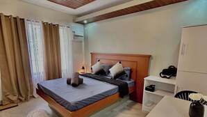 Un dormitorio con cama, mesita de noche y escritorio con silla.