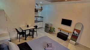 Un dormitorio moderno con cama, escritorio y televisor.