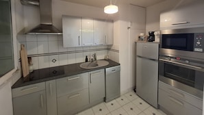 A modern kitchen with stainless steel appliances, a built-in oven, microwave, and dishwasher.
