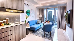 Un appartement moderne comprenant une cuisine, un canapé bleu, un coin repas et une grande fenêtre donnant sur la ville.