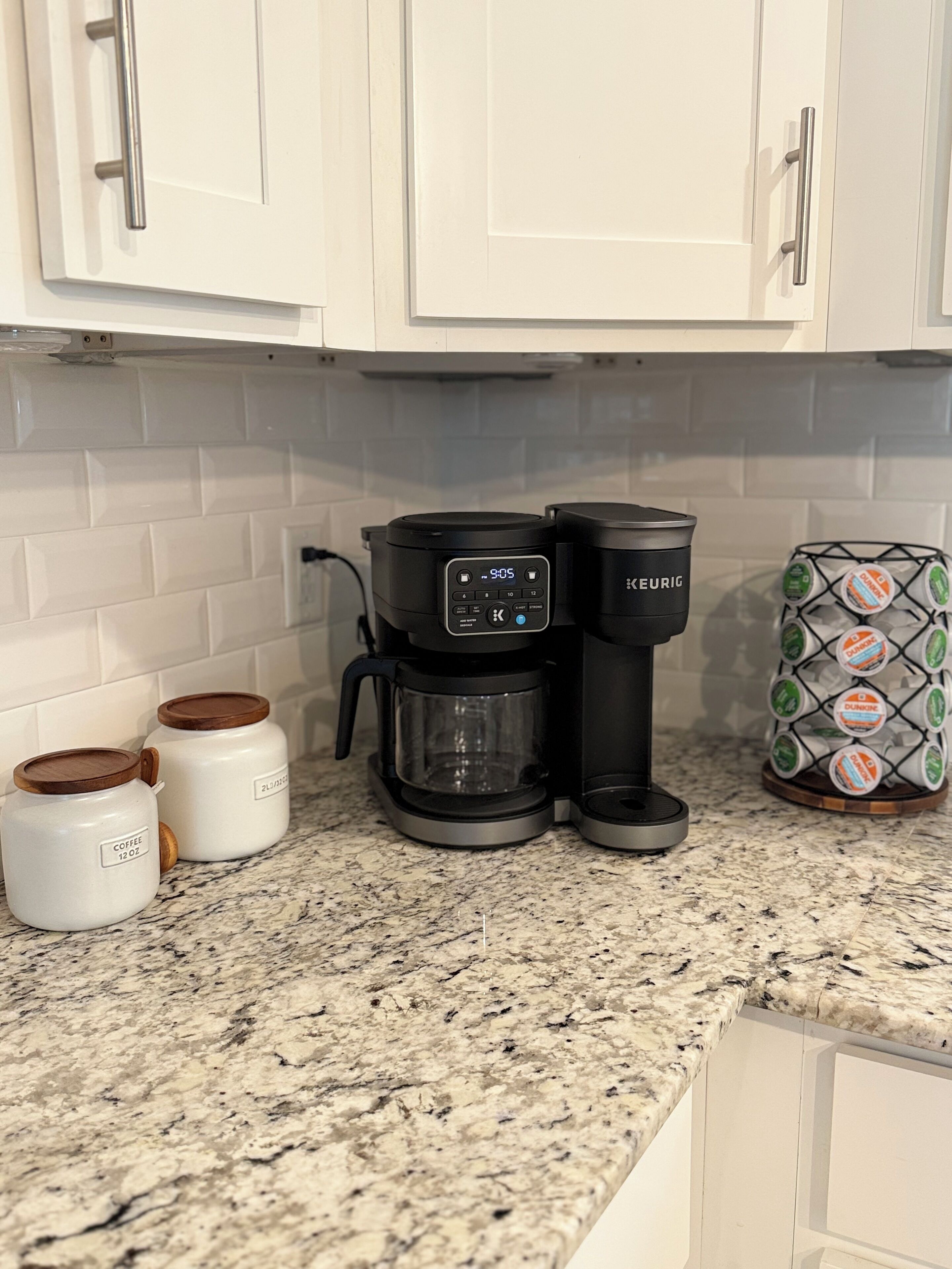 Eine Küche mit Kaffeemaschine, zwei Kaffeebehältern und einem Kaffee-Pod-Halter.
