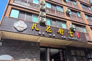 Un bâtiment sur lequel on peut voir une enseigne de restaurant écrite en caractères chinois, un numéro de téléphone et une adresse de site web.
