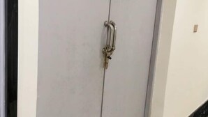 A white door with a metal handle and a keyhole.