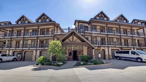 A multi-story hotel with a central entrance, balconies, and a parking area. - Walk to Main Street | Hot Tub, Gym and Game Room (Breckenridge)