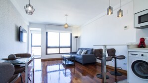 A modern apartment with a dining area, living room, and kitchen. - CASTELLANA PARKING 1 BEDROOM - 02 (Madrid)