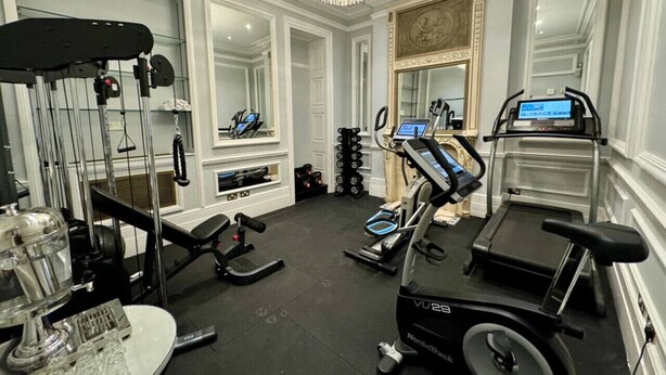 A gym with treadmills, weight machines, and a mirror.