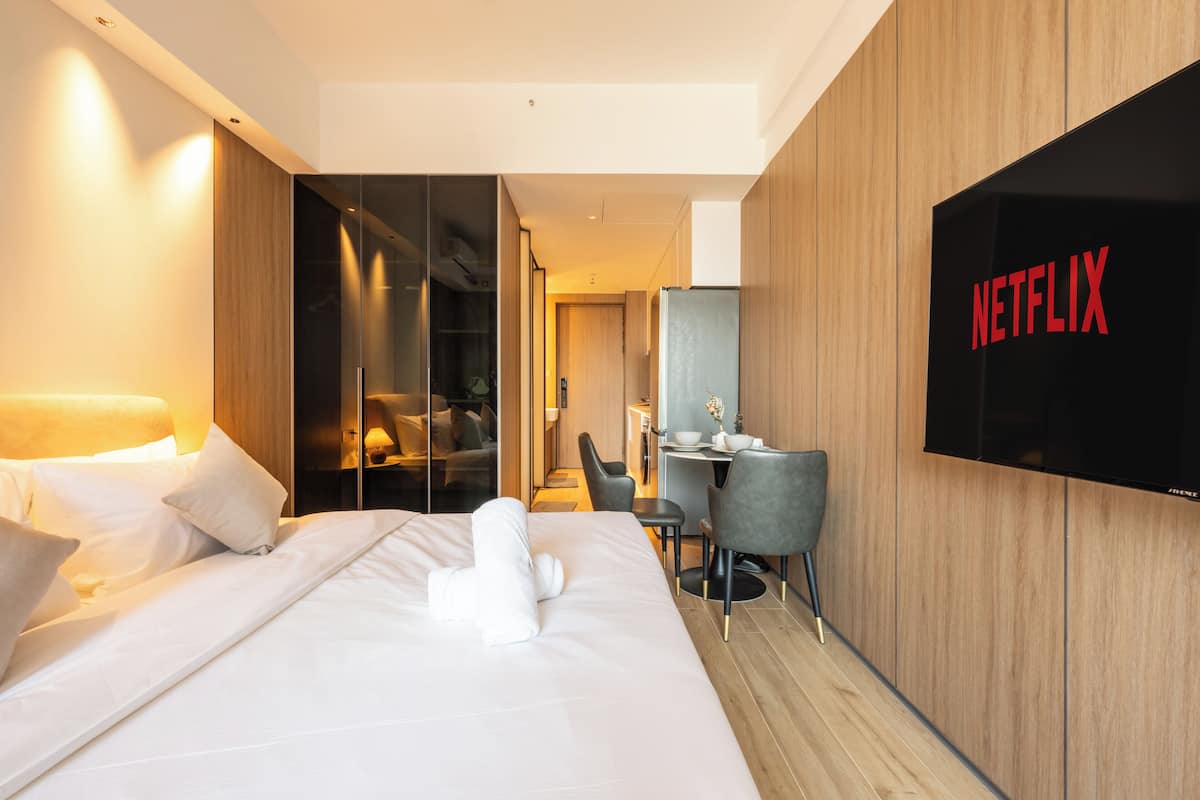Ein modernes Hotelzimmer mit einem Bett, einem Schreibtisch und einem Fernseher mit dem Netflix-Logo.