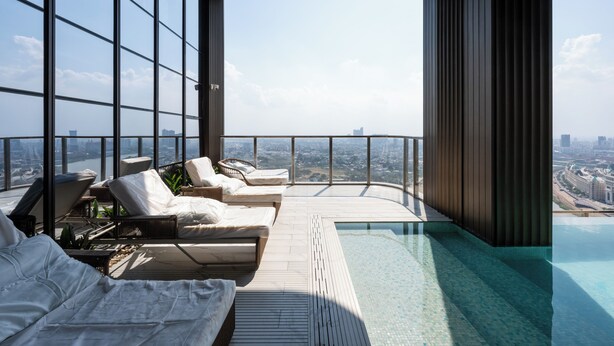A rooftop infinity pool with lounge chairs and a view of the cityscape. - Vue Aston Condominium by Soben Homes (Phnom Penh)