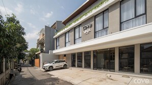 A modern building with a storefront labeled 'Cove VIA' and a white SUV parked in front. - Cove Vaia (Bandung)