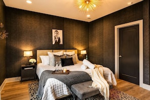 Dark patterned wallpaper and a Sputnik chandelier give the king bedroom a moody edge, perfect for a host who wants their own quiet sanctuary - Fall Nashville escape | sleeps 12 | 4BR townhome near Nissan Stadium (Nashville)