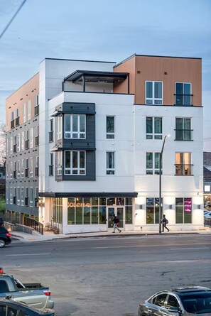 A multi-story building with a flat facade, large windows, and a ground-level commercial space.