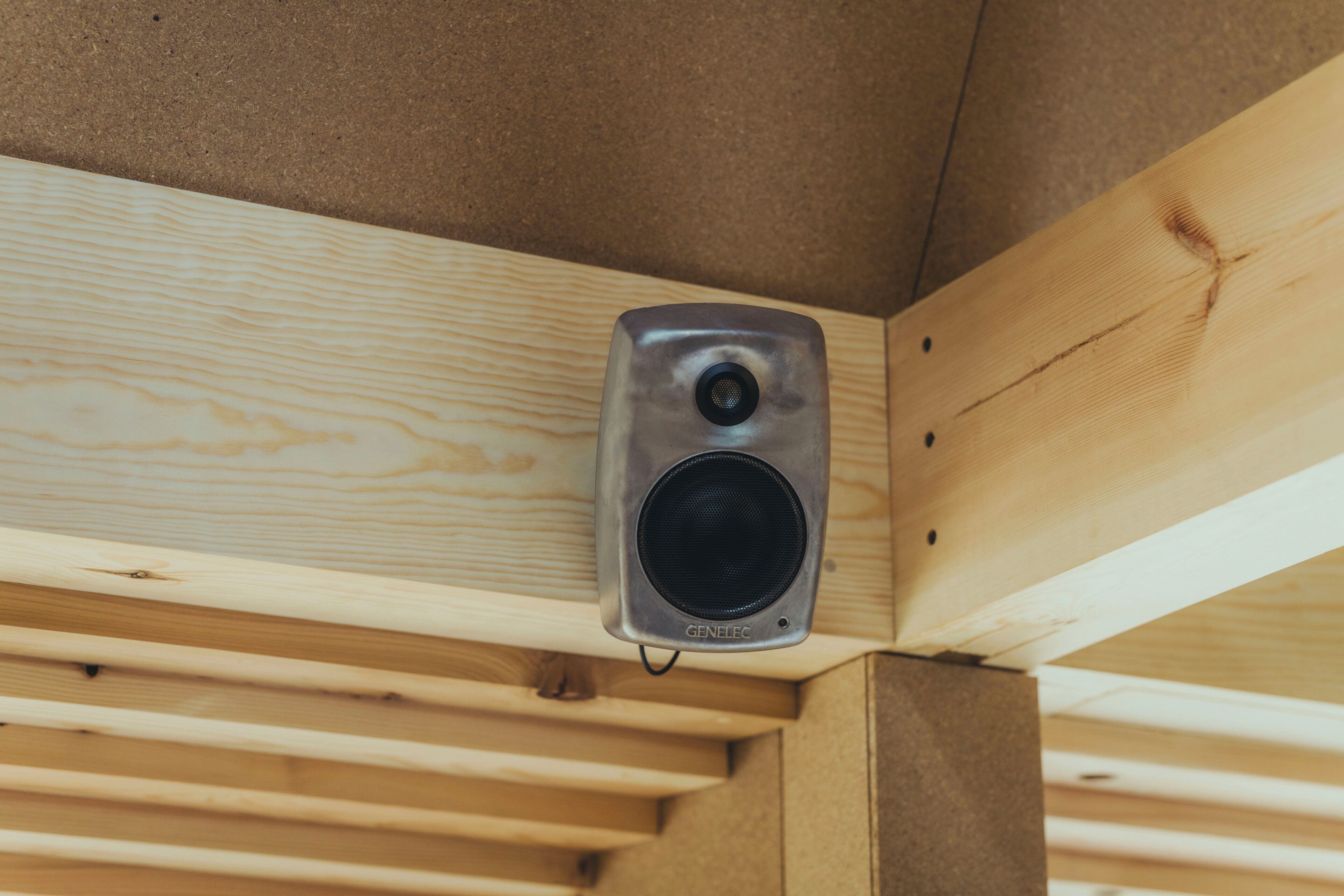 A speaker mounted on a wooden structure.