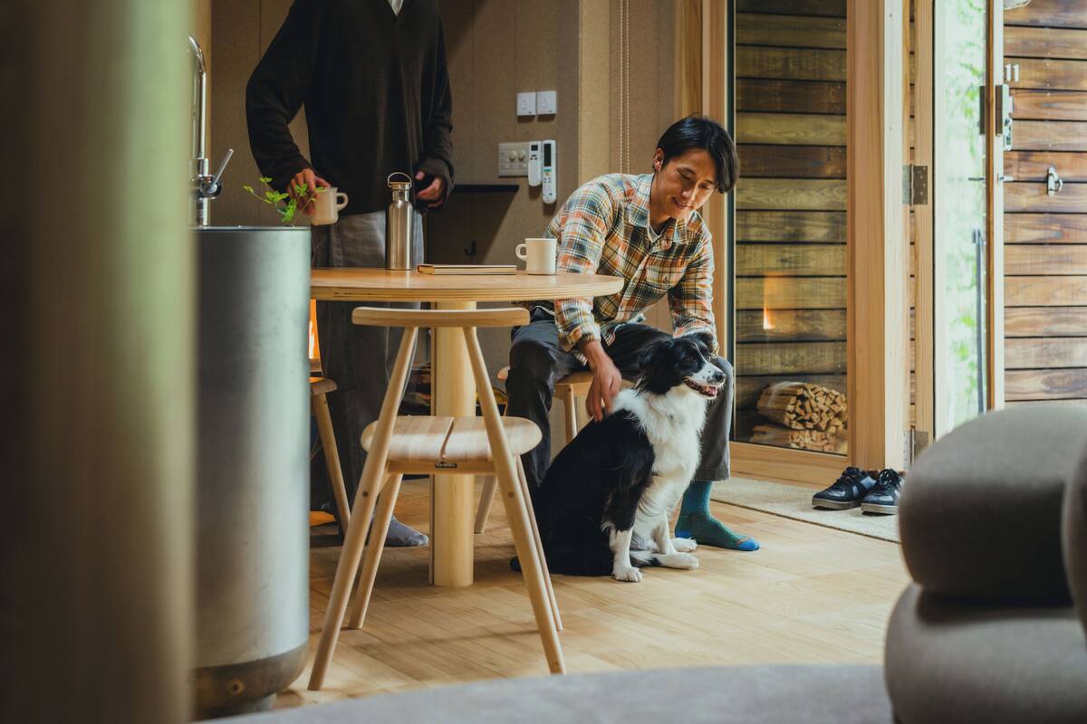 Une pièce chaleureuse avec un plancher en bois, une table ronde et un distributeur d’eau en métal.