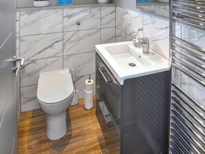 A bathroom with a toilet, a sink, and a mirror.