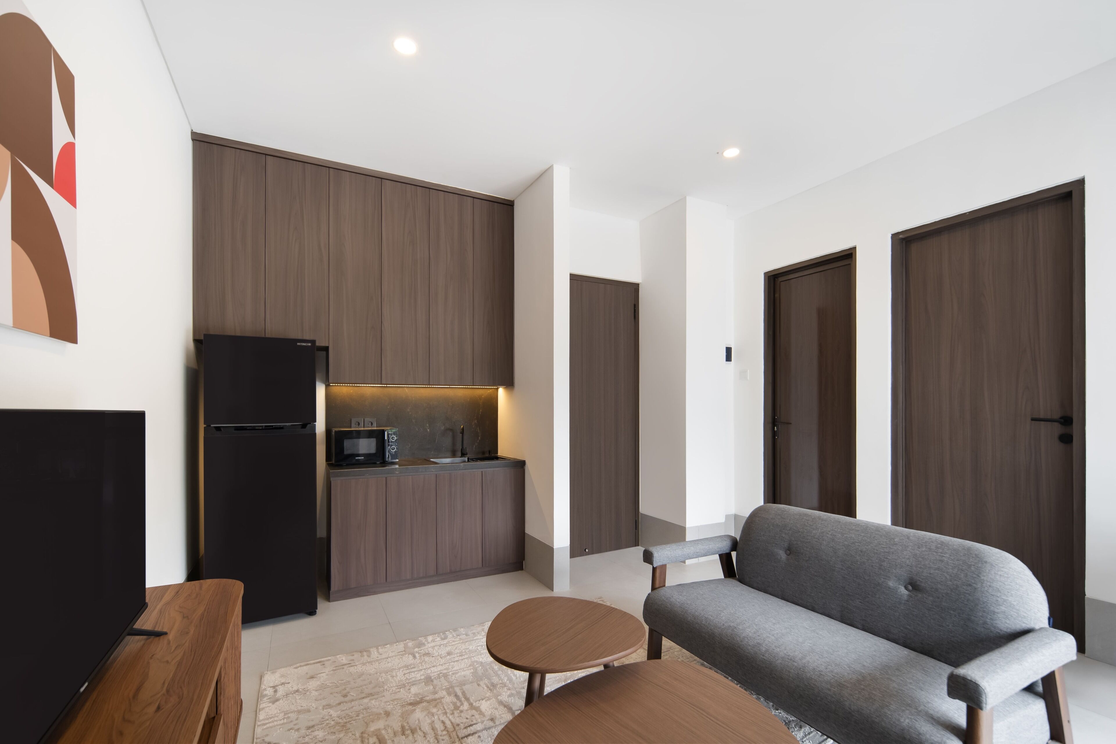 Ein modernes Wohnzimmer mit grauem Sofa, einem Holztisch und einer schwarzen TV-Konsole.