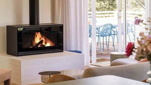 Una sala moderna con chimenea, una mesa de comedor y sillas.