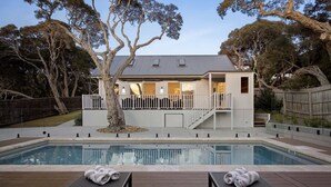 A modern house with a swimming pool, wooden deck, and a covered patio area. - Saltwood Coastal Hamptons Luxe with Pool (Rye)