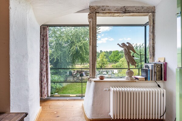A room with a large window, a radiator, and a sculpture on a table.