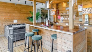Ein Holzinne mit einer Bar, Barhocker, einer Couch und einem Feuerlöscher.