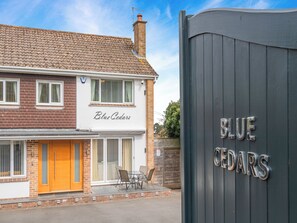 A two-story building with a sign reading 'Blue Cedars.'