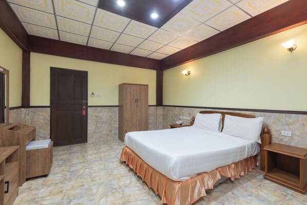 A hotel room with a large bed, wooden furniture, a wardrobe, and a nightstand. - Kata Palace Phuket Hotel (Karon)