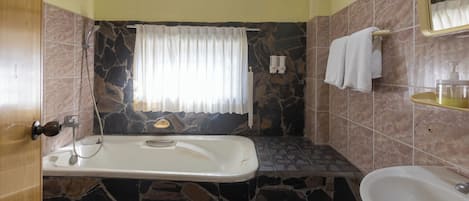 A bathroom with a bathtub, a sink, and a shower.