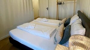 A double bed with white linens, a wooden headboard, and a bedside table with a lamp. - Holiday Home in Voerendaal With Terrace (Voerendaal)