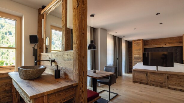 Un bagno moderno con uno specchio grande, un mobile lavabo in legno e una vasca da bagno.