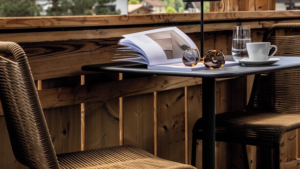 A wooden deck with a table, chairs, and a book. - Vacation apartment 4, 60 sqm, with high-quality furnishings (Reit im Winkl)