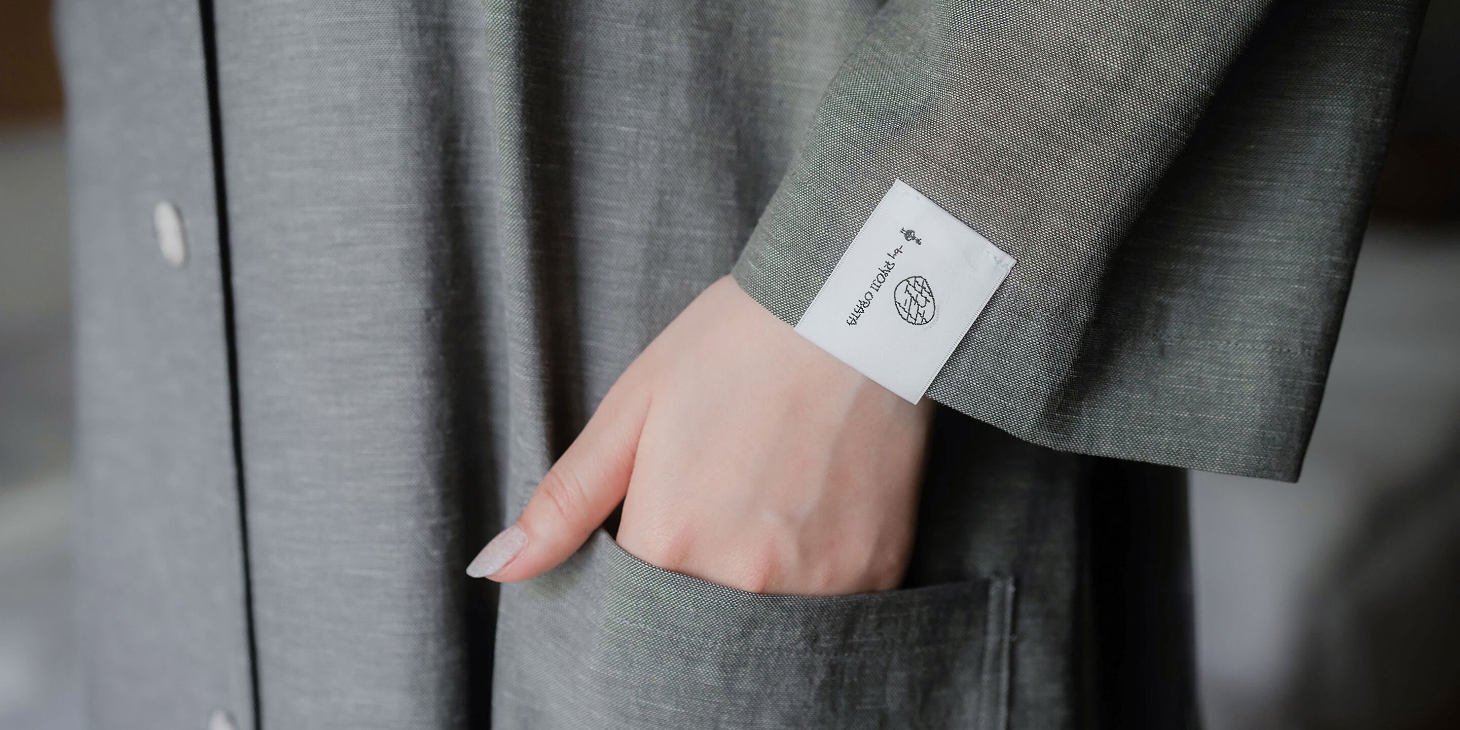 A hand with a name tag in a pocket.