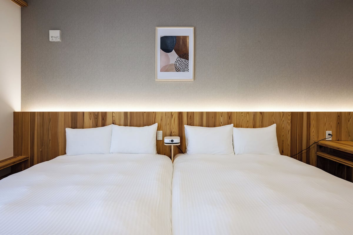A double bed with a wooden headboard, two bedside tables, and a framed picture on the wall.