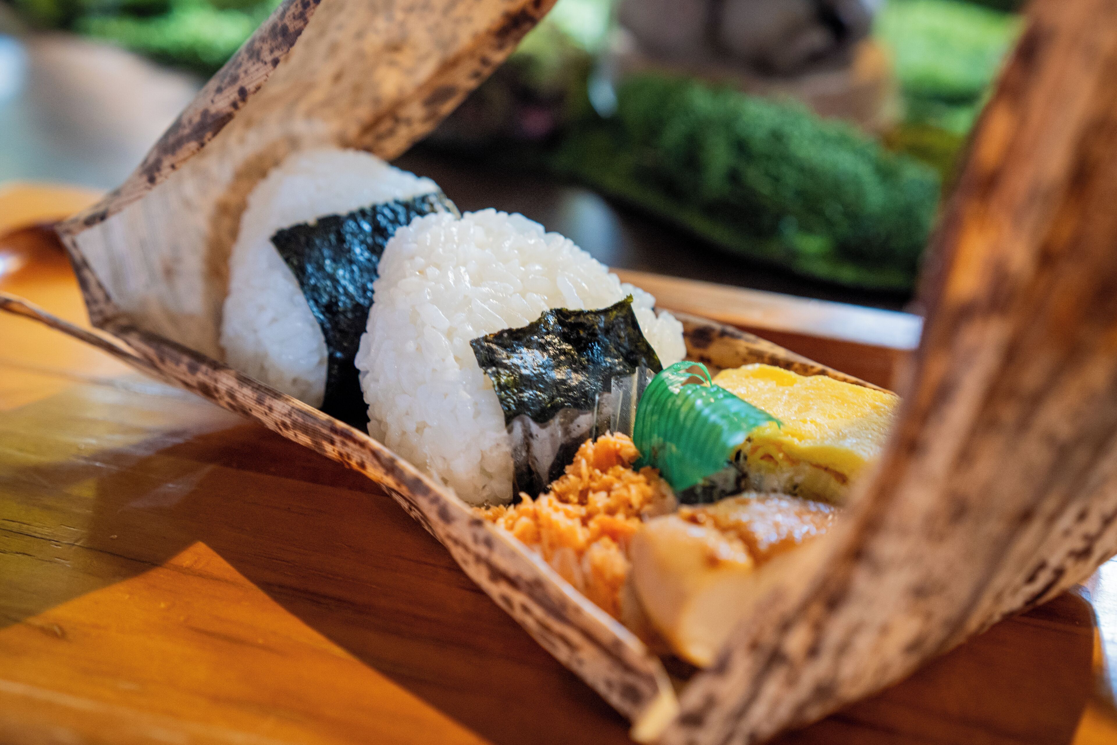 Un plato de sushi con arroz, alga y otros ingredientes sobre una mesa de madera.