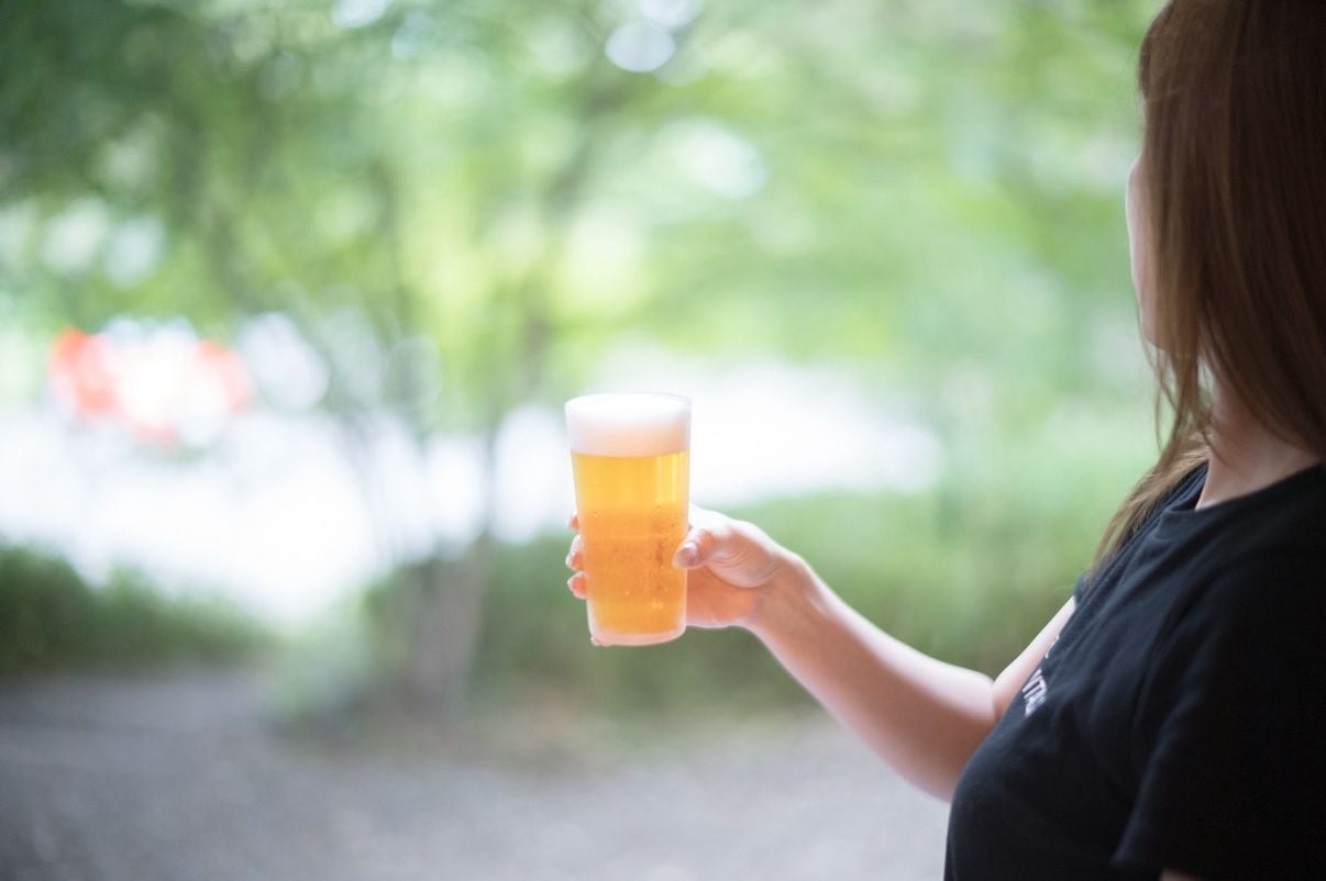 A person holding a glass of beer.