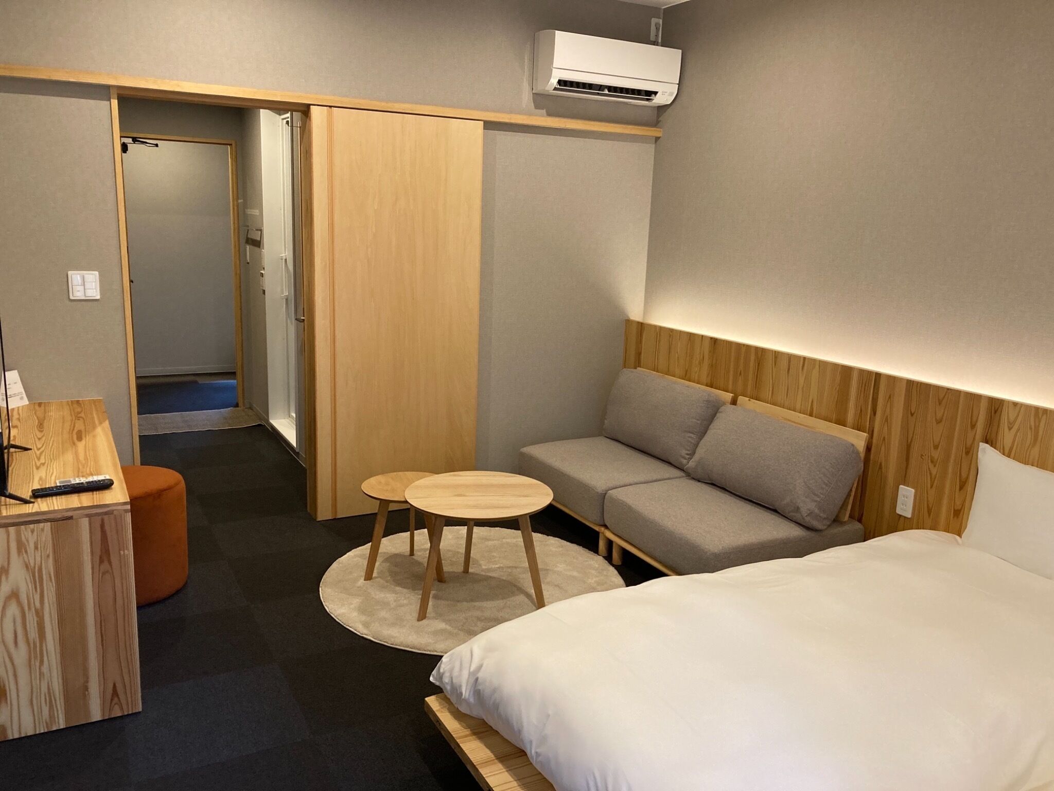 Une chambre d’hôtel avec un lit, un canapé, une petite table et un bureau avec une télécommande.