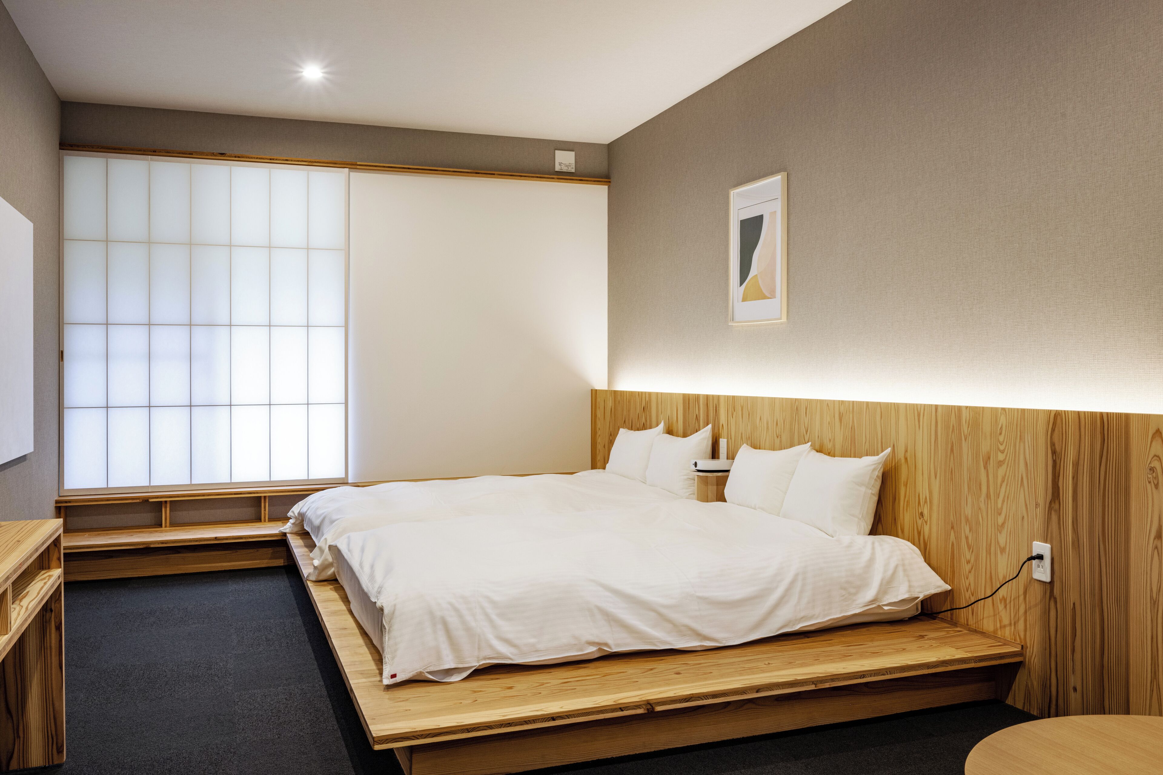 Un dormitorio con cama, cabecera de madera y un ventanal con persianas.