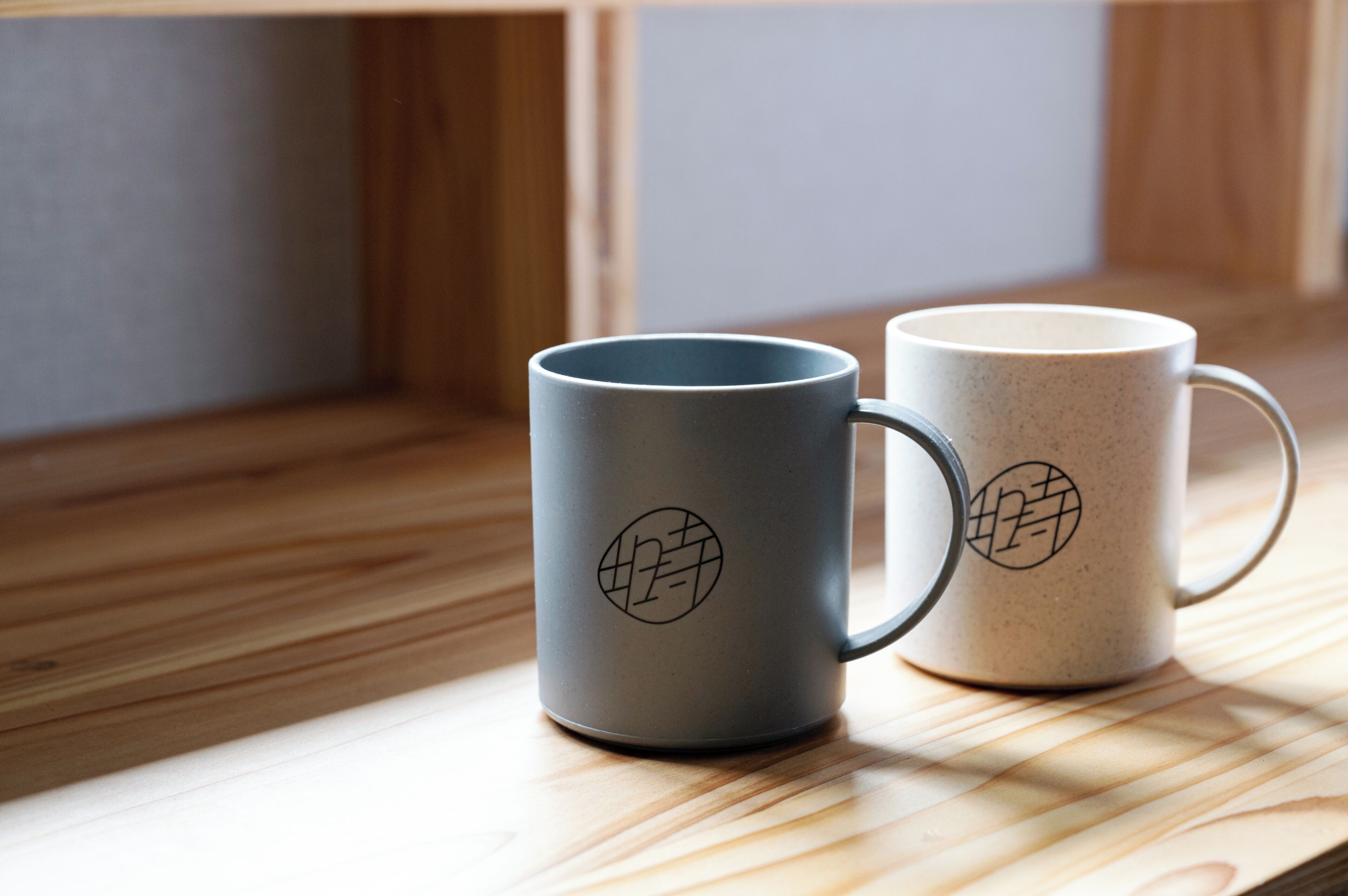 Dos tazas de cerámica con un diseño geométrico sobre una superficie de madera.