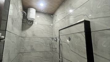 A modern bathroom with a toilet, shower, and a towel rack.