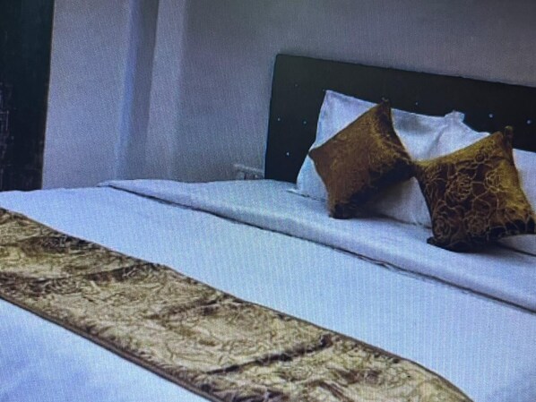 Una cama con una colcha estampada y dos almohadas.