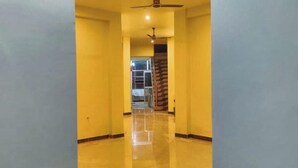 A hallway with a ceiling fan, a staircase, and a door leading to another room. - Hotel Ganga Sagar (Bhatwari)