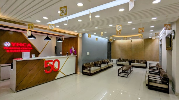 A reception area with a reception desk, sofas, and a seating area. - YMCA Training Center and Guest House  (Savar)