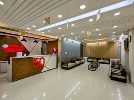 Uma área de recepção com balcão, sofás e espaço para sentar.
