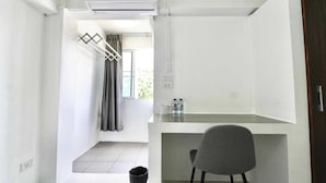 A small, modern room with a desk, chair, and an air conditioning unit. - Cozy Double Stay | Near Suvarnabhumi Airport Hub (Bangkok)