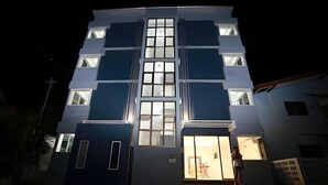 A modern building with a central glass facade and a staircase leading to the entrance. - Cozy Double Stay | Near Suvarnabhumi Airport Hub (Bangkok)