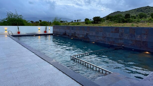 Una piscina con un muro de piedra y un suelo de metal.