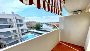 A balcony with a view of a swimming pool and adjacent buildings. - Holiday Home in Caorle near Spiaggia Tartaruga (Porto Santa Margherita (VE))