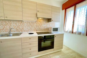 Fridge, microwave, stovetop, dining tables - Apartment in Porto Santa Margherita by Beach (Porto Santa Margherita)