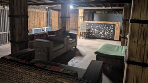Un intérieur rustique avec des meubles en osier, un coin bar et des murs en bois.