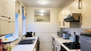 A compact kitchen with a sink, stove, microwave, and oven. There are cabinets and a countertop.