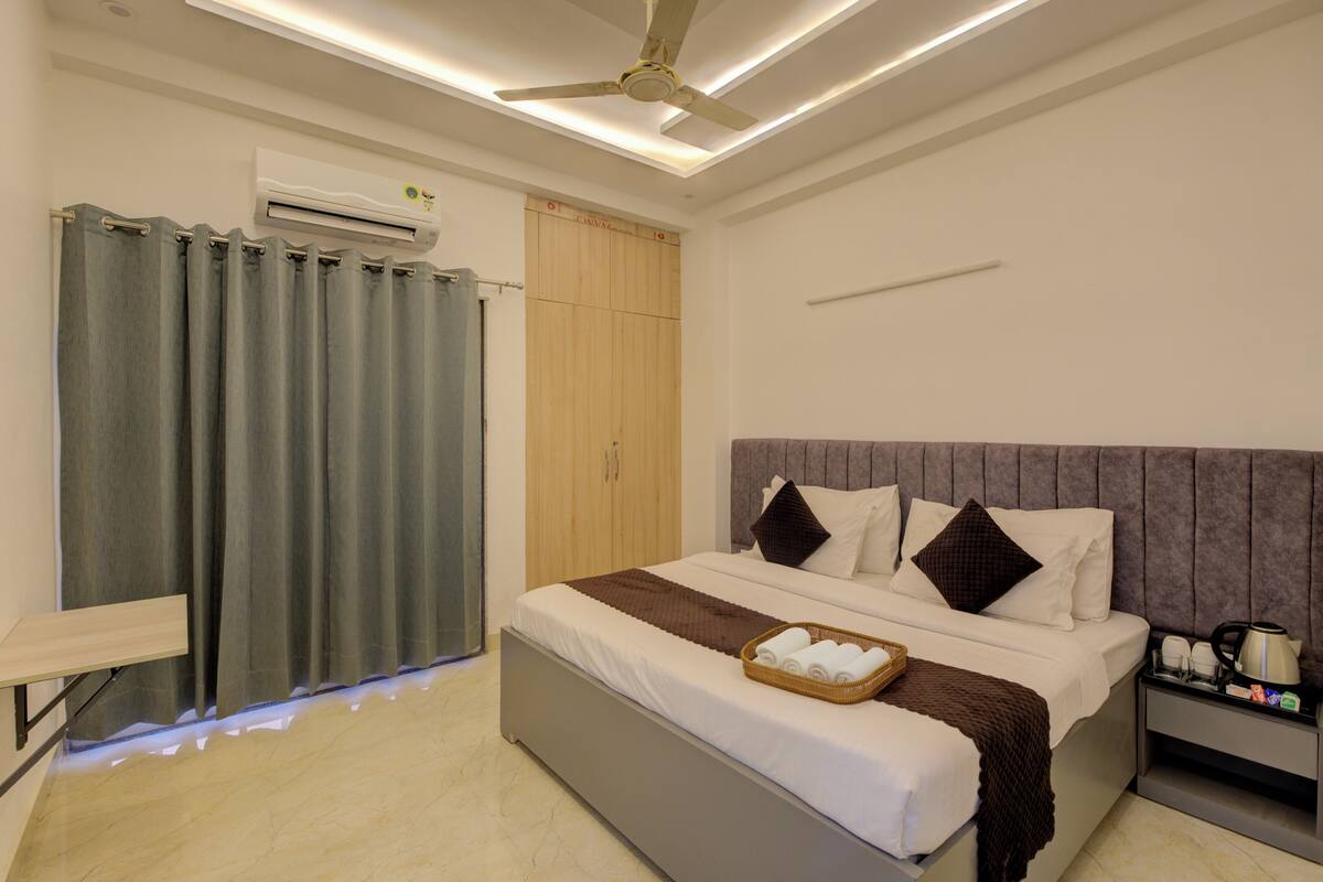 Una habitación de hotel moderna con cama, mesita de noche y ventilador de techo.