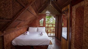 A cozy, rustic bedroom with a large bed, wooden walls, and a view of greenery outside. - Bamboo Dale Resort (Udumbanchola)